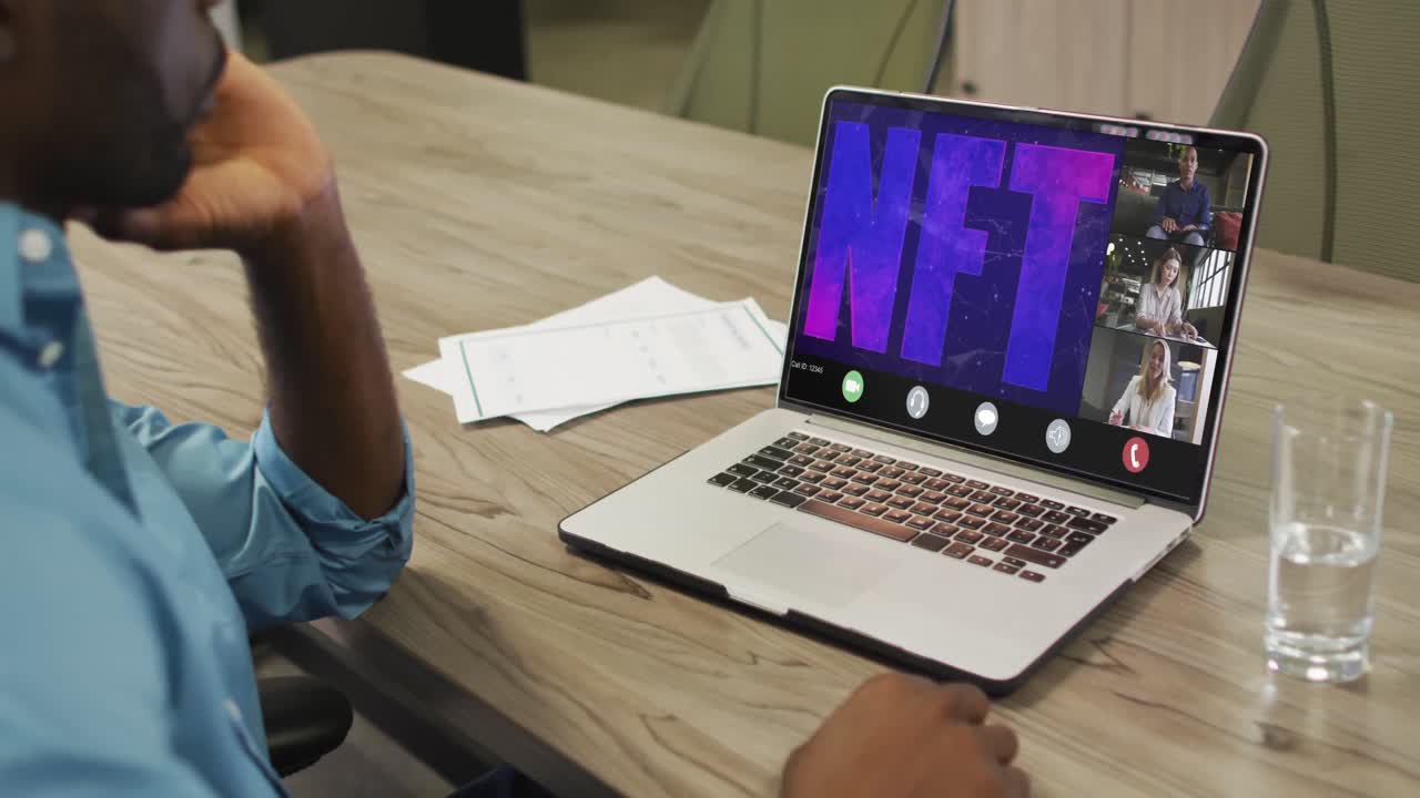 video de un hombre afroamericano haciendo una videollamada nft en una computadora portátil con varios compañeros de trabajo