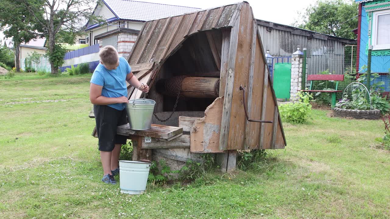 소년은 우물에서 물 한 바구니를 가져와 다른 바구니에 부었습니다.