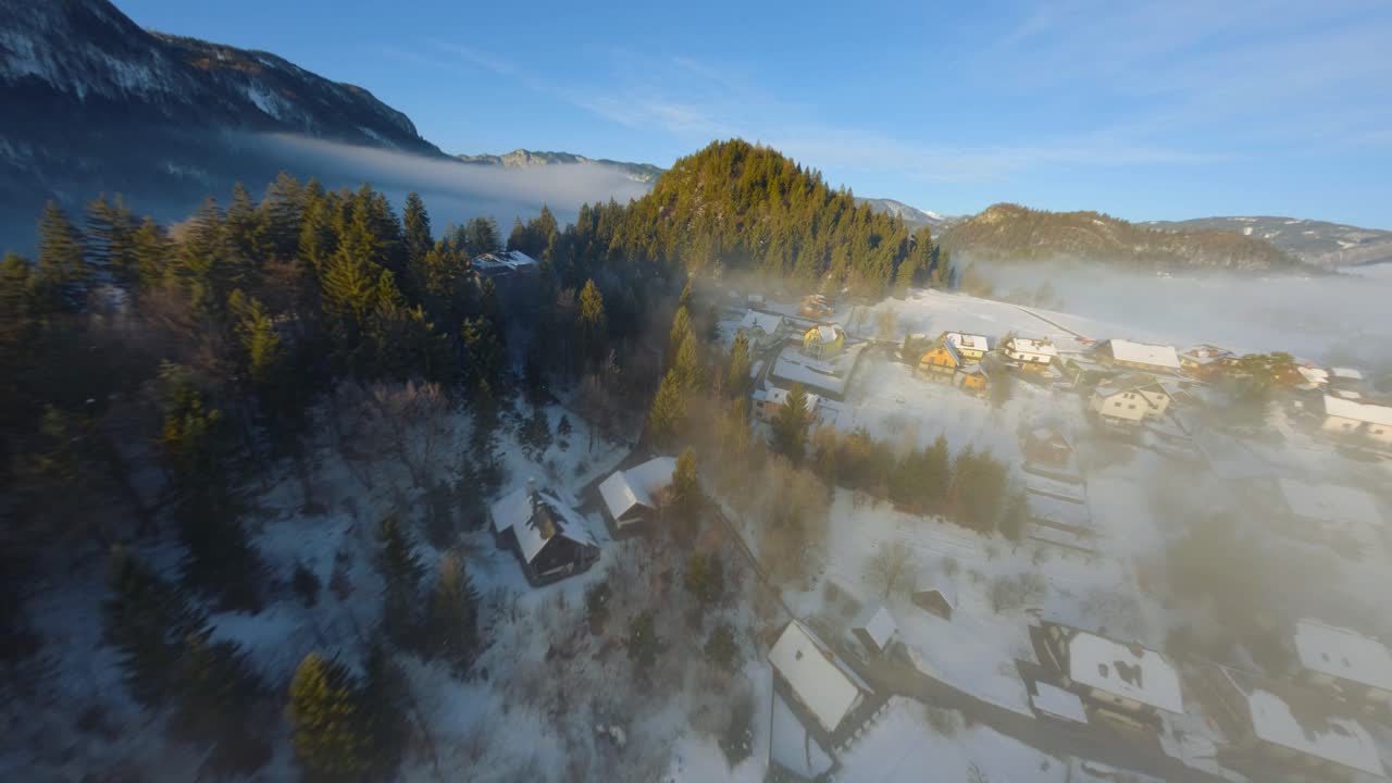 Ripresa da drone FPV del paesaggio sloveno avvolto nella nebbia con montagne circostanti al mattino d'inverno, catturato in 4K, con il drone che vola velocemente, vicino agli oggetti e con molto movimento.