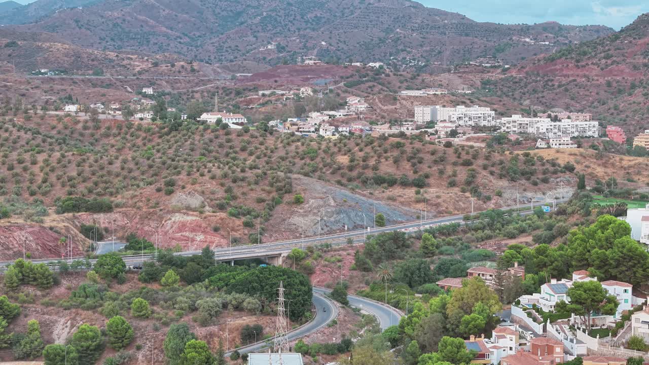 Malaga hillside showing roads, olive fields, and whitewashed homes nestled in rugged mediterranean terrain