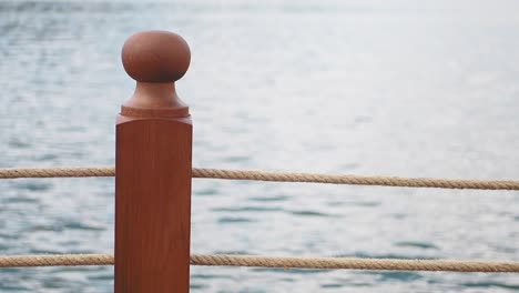 wooden post and rope railing by the water