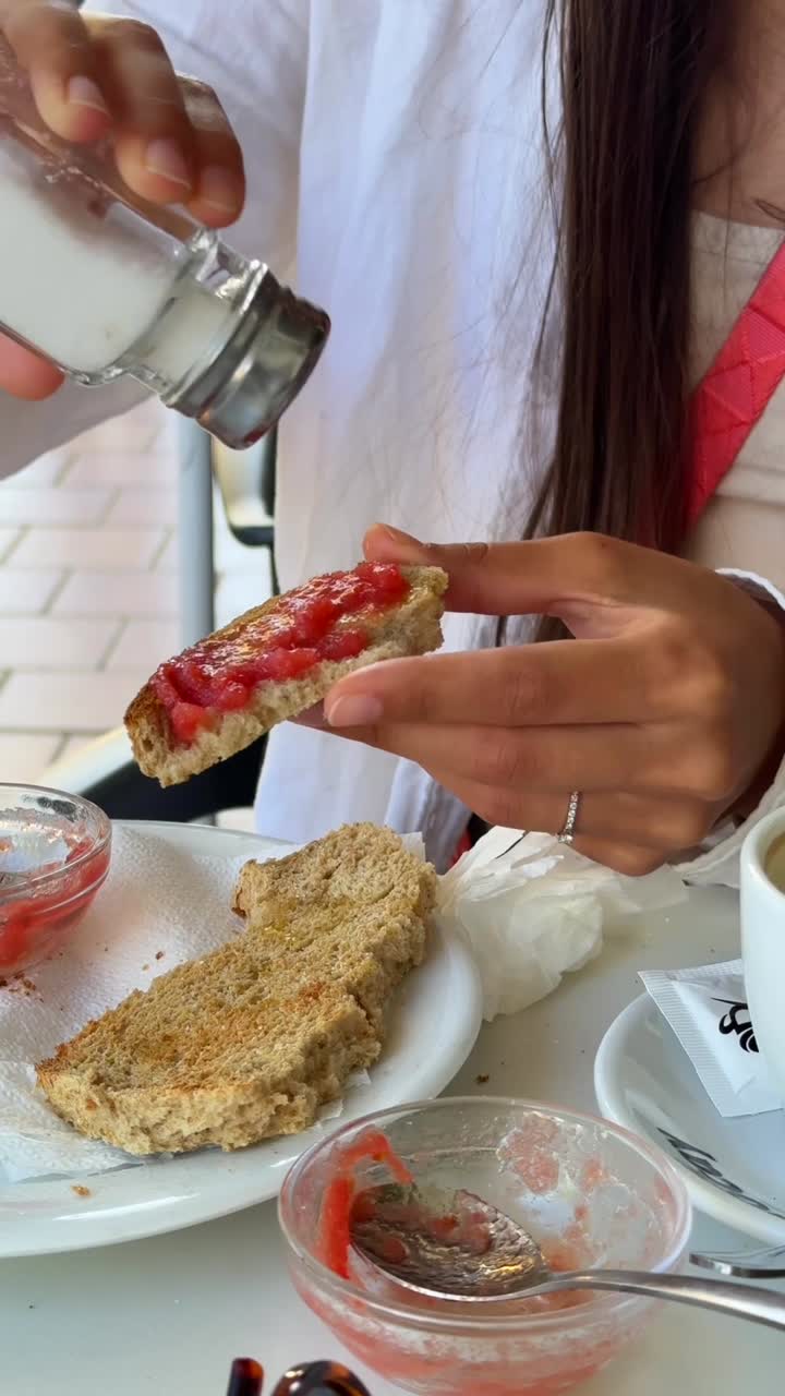 Donna che spalma pomodoro fresco sul toast per colazione