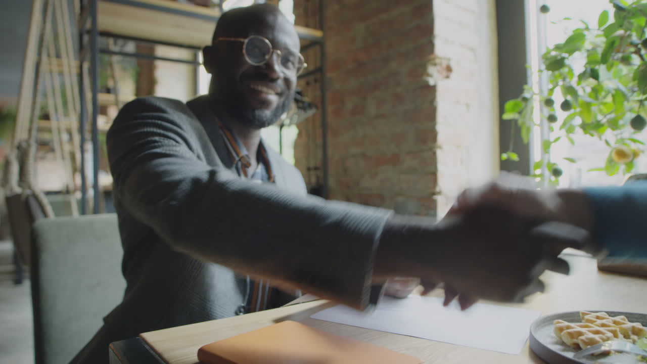 Businessman Striking Deal on Lunch in Cafe