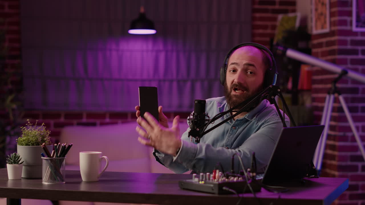 Vlogger influencer recording product review for modern smartphone with professional audio equipment