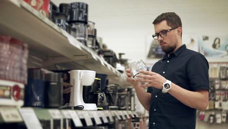 man shopping for coffee maker and cup in a store