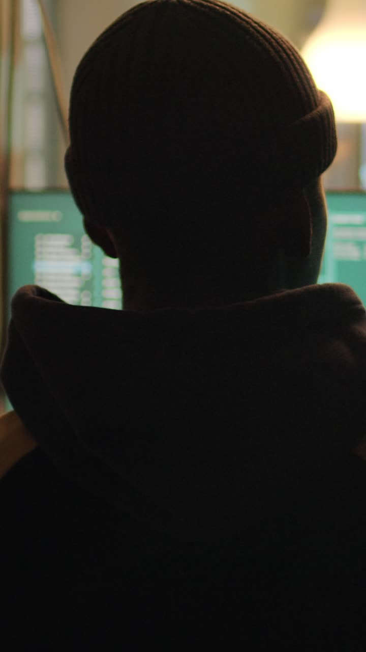 Video verticale: silhouette di un hacker che viola la crittografia del firewall per impiantare un virus trojan
