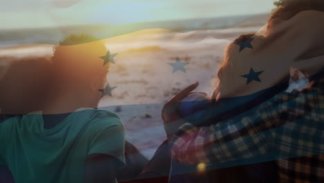 animación de ondear la bandera de honduras sobre un grupo de amigos divirtiéndose en la playa