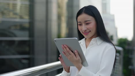 asian woman using digital tablet in urban setting
