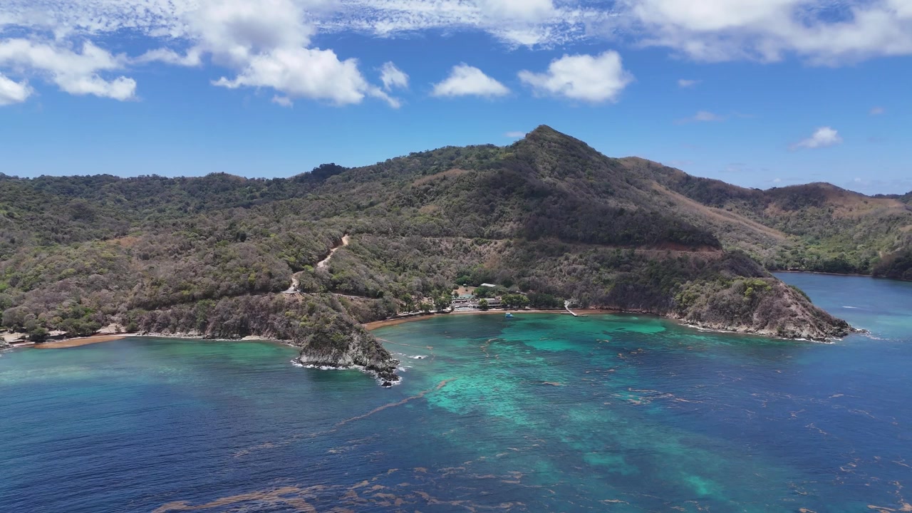 Vista aerea con drone della costa a Speyside, Isola di Tobago. Acqua cristallina turchese e rigogliose colline tropicali della costa caraibica a Trinidad e Tobago durante una giornata di sole.