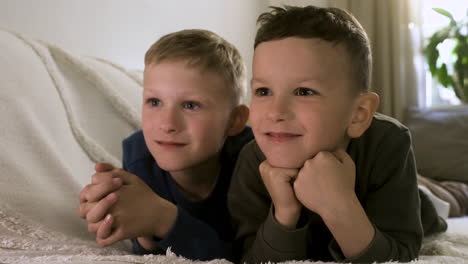 niños felices disfrutando de una película en el sofá