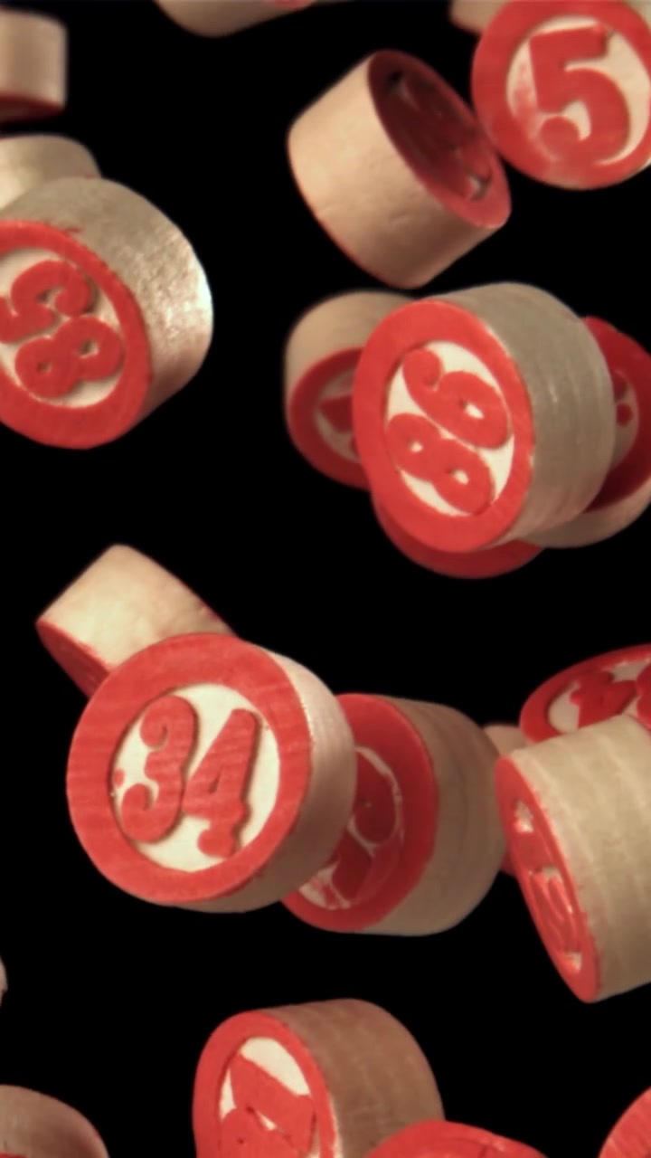 Rot-weiße nummerierte Bingo-Chips fallen in Zeitlupe