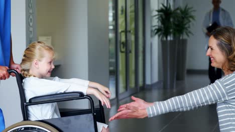 nurse pushing girl in wheelchair