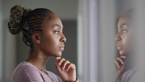 Thoughtful-african-american-woman-looking-outside-window