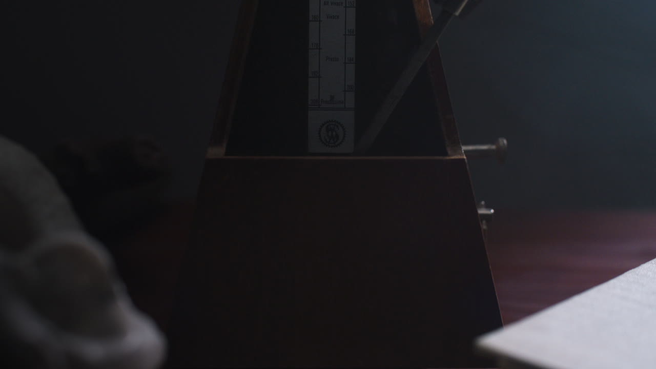 Metronome set the rythm in the dark, old room