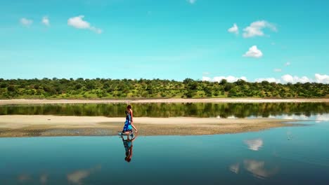 Touristische-Frau-Mit-Masai,-Die-Entlang-Des-Magadi-sees-In-Kenia-Spazieren-Geht---Drohnenaufnahme