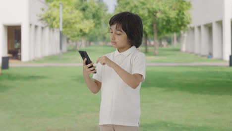 Niño-Indio-Desplazándose-Por-El-Teléfono-En-El-Parque