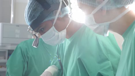 Portrait-of-biracial-female-surgeon-wearing-flashlight-on-head-in-operating-theatre,-slow-motion