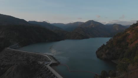 Reserva-De-Agua-Región-Montañosa-Represa-Hidroeléctrica-Ambuklao-Lago-Revelador-Rodeado-De-árboles-Montañas-En-área-Remota-Luzon,-Bokod,-Benguet,-Filipinas-Antena-Amplia-Marcha-Atrás-Camino-Revelador