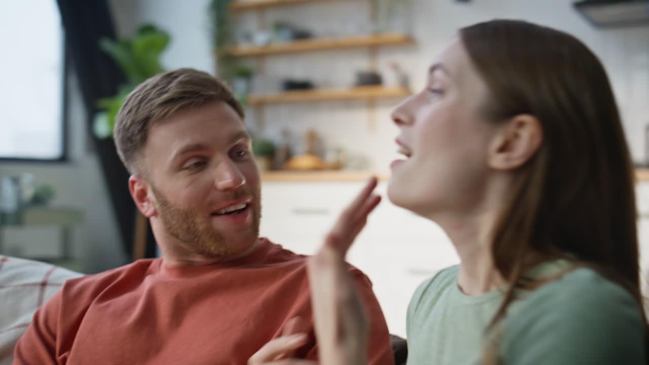 Family couple laughing together falling on cozy couch closeup. Loving spouses