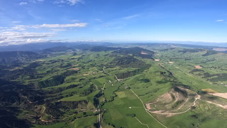 aerial shot flying over green fields and pastures near methven, new zealand