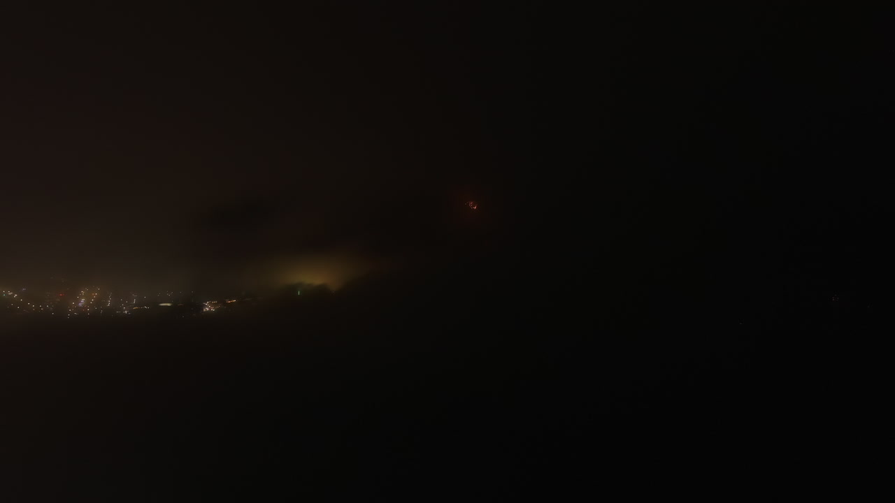 7월 4일 어두운 도시 위로 안개가 자욱한 밤하늘에서 불꽃놀이가 빛난다