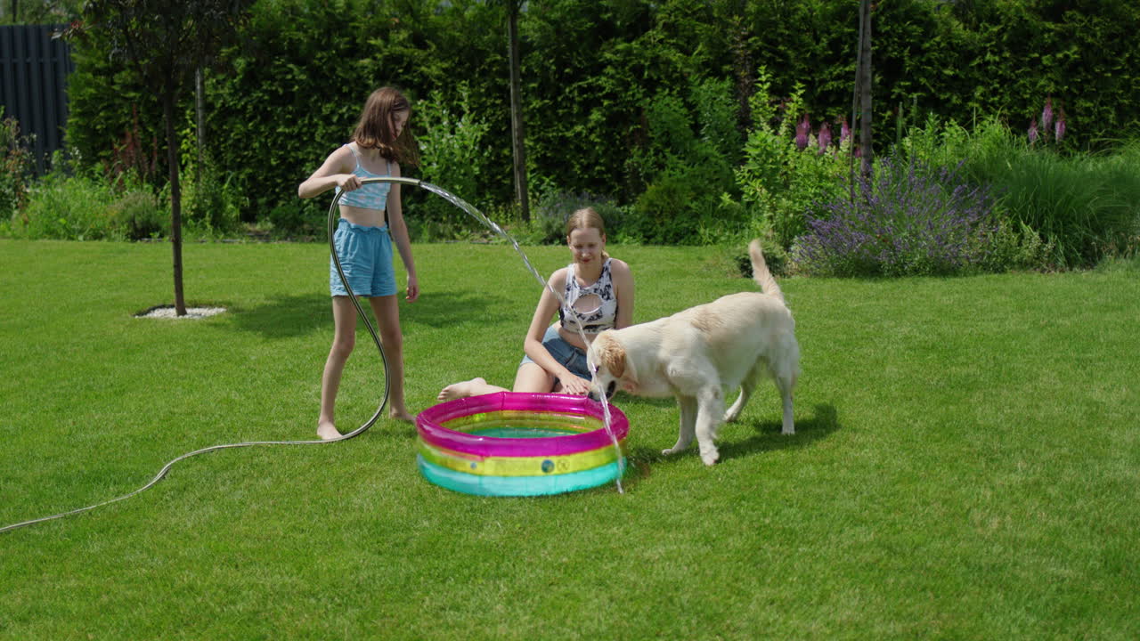 Bambini e cane che si godono il divertimento estivo in giardino