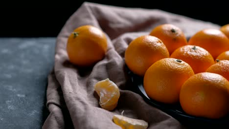 pile of unpeeled round ripe orange mandarin in a plate