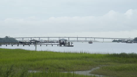 Boat-Traveling-Along-River-Near-Marsh-Grass-in-Chalreston,-SC,-Static