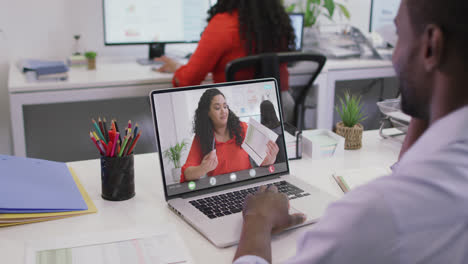 Video-of-african-american-man-having-video-call-on-laptop-with-biracial-female-coworker