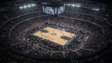 an aerial view of an exciting basketball game in a packed arena, showcasing the thrilling atmosphere and enthusiastic fans cheering for their teams