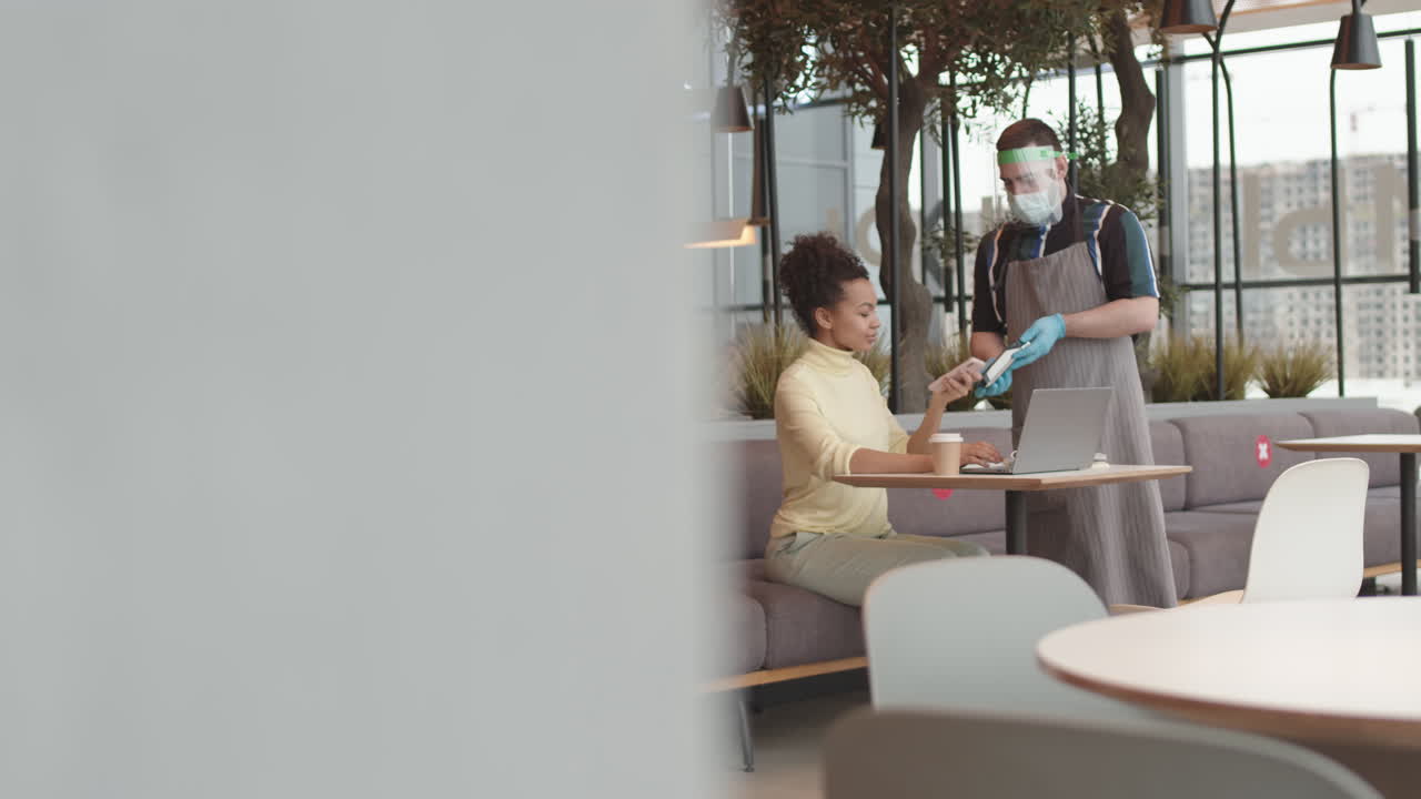 Customer Paying with Smartphone in Coffee Shop