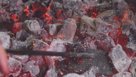 burning coals mixed by iron stick