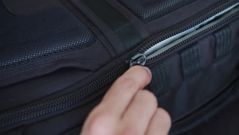 amazing close up slow motion shot of a young man's hand unzipping a black camera suitcase