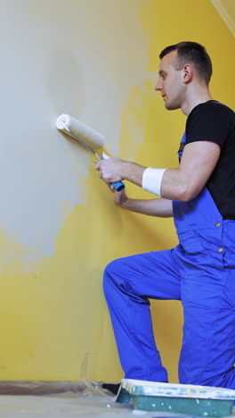 professional repairman renovating the room. handsome painting master doing room renovation. vertical video