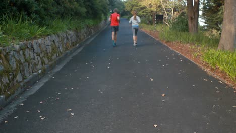 Pareja-Corriendo-En-La-Carretera-Abierta