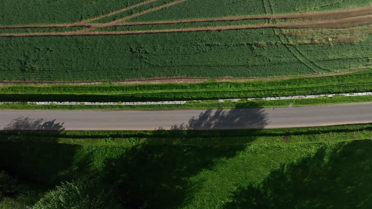 Caledon Border Wall, County Tyrone, Northern Ireland, May 2023. Drone birdseye view moves right above border wall and lush farmland scenic aerial view on sunny day.