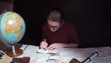 caucasian millennial man sitting down, journalling about traveling