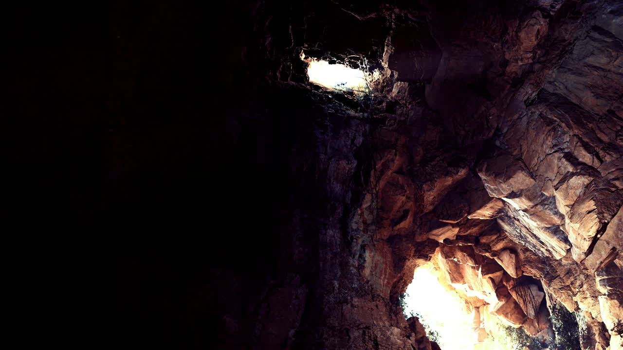 Dark cave with bright openings showcasing natural rock formations