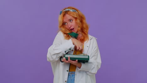 Sincere-redhead-girl-talking-on-wired-vintage-telephone-of-80s,-fooling,-making-silly-funny-faces