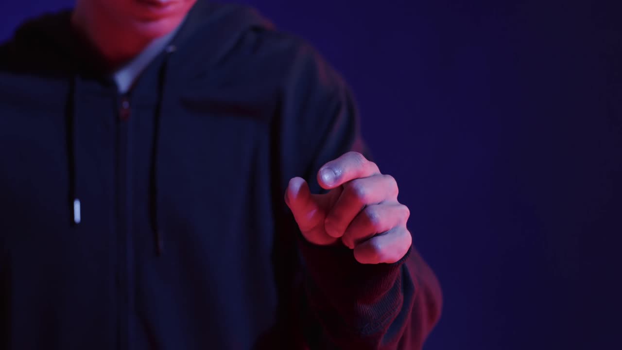 sección media de un hombre asiático, tocando la pantalla virtual sobre fondo azul, cámara lenta