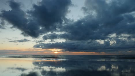 Lapso-De-Tiempo-De-Una-Hermosa-Puesta-De-Sol-Nublada-Y-Su-Reflejo-En-Un-Charco-De-Agua-En-Una-Playa-Báltica-En-Letonia