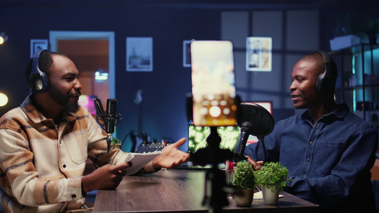 Men meeting in studio to film show with mobile phone and talk politics