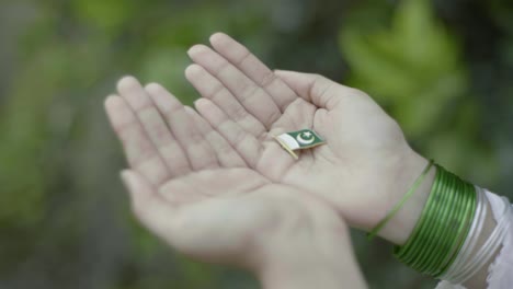 revealing a pakistan flag brooch pin in hands, symbol of country pride and islam