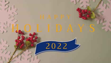 Animation-of-happy-holidays-2022-christmas-text-over-decorations-on-light-green-background