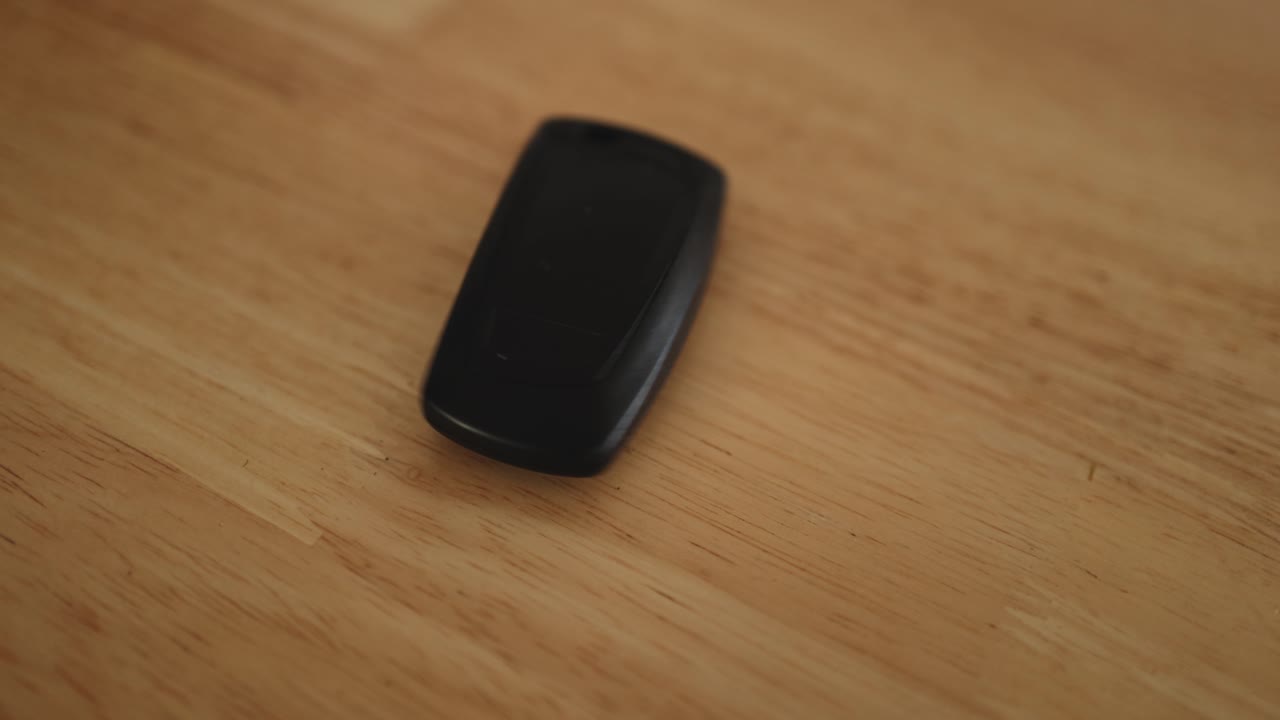 A car key flipping and rotating on a table.