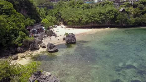 Padang-Padang-Beach,-Tiefflug-über-Kristallklarem-Wasser-Mit-Felsvorsprung-Am-Meer