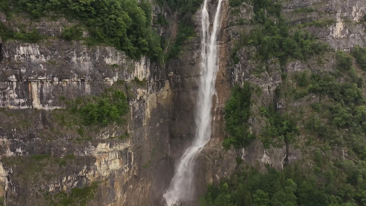 Aerial view of Seerenbachfälle waterfall in Amden Betlis, near Lake Walensee, Switzerland. Towering cascade plunging down a steep cliff, surrounded by rugged rock walls and forest