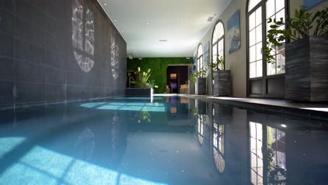 low angle panning shot of indoor luxurious swimming pool of a modern mansion