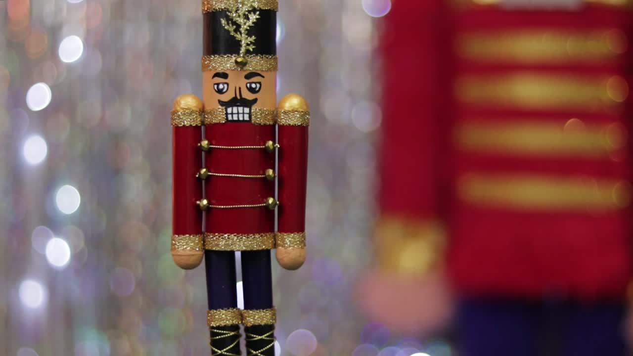 Toy soldier nutcracker on table, same but huge figurine in background