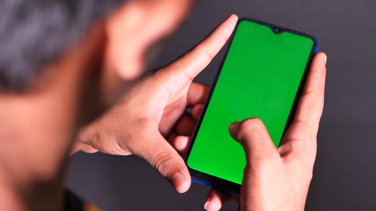persona que sostiene un teléfono inteligente con una pantalla verde